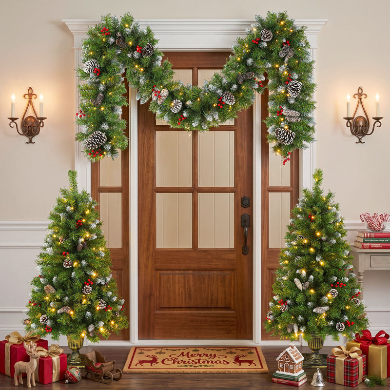 Pre-lit artificial Christmas trees and pinecone garland displayed around an entrance