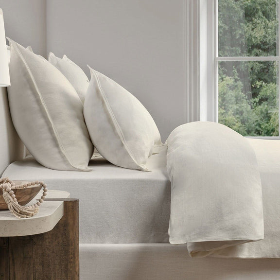 Ivory linen-look duvet with multiple pillows and a draped matching throw