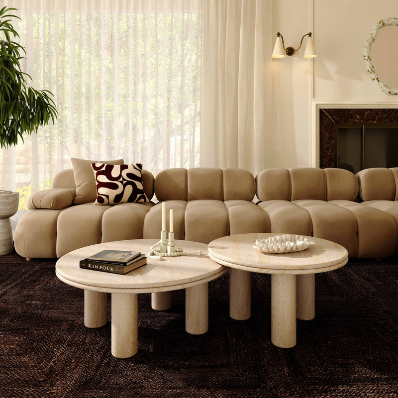 Beige round accent table with textured top on short pedestal legs