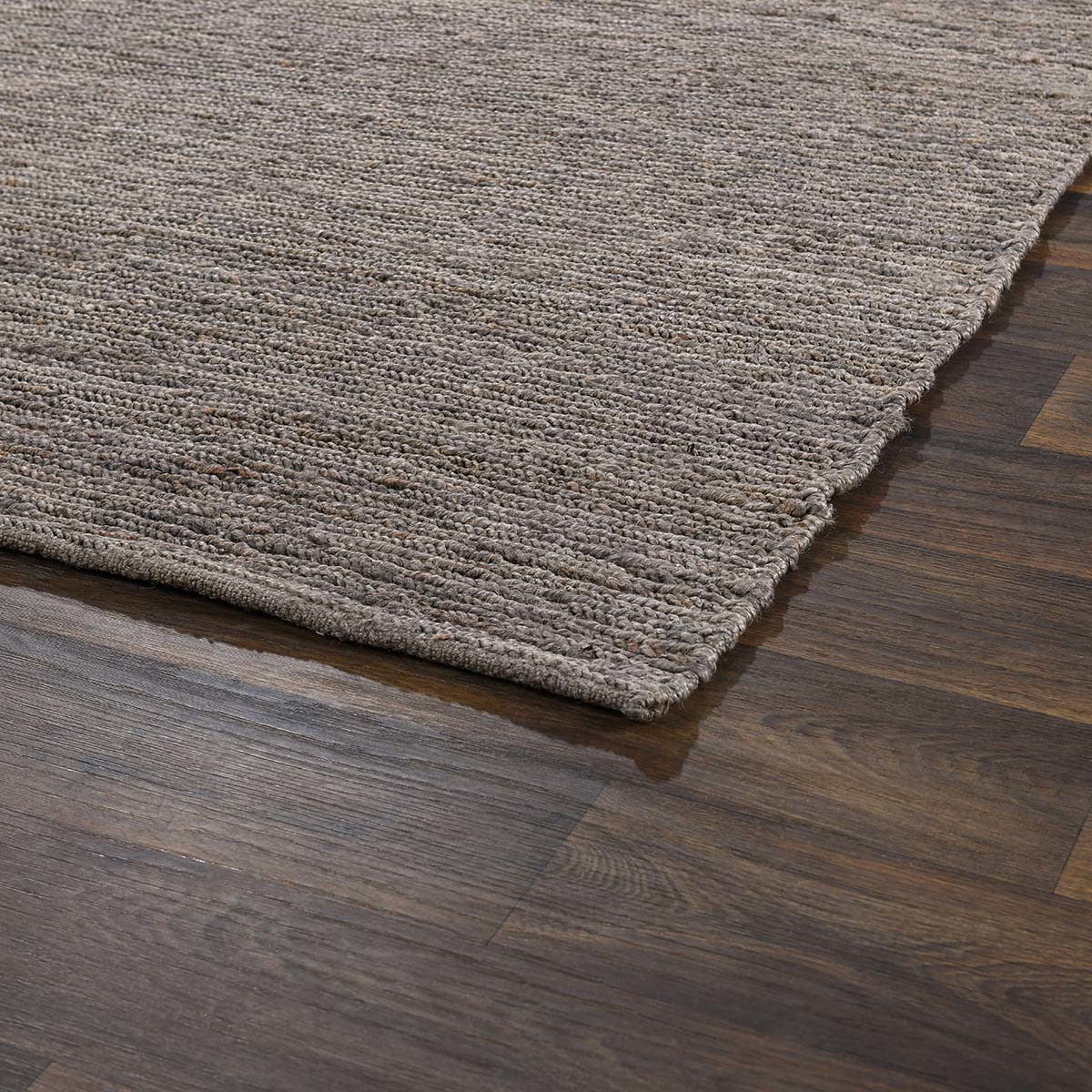 Close-up of gray jute area rug flat weave texture with short fringe along one edge