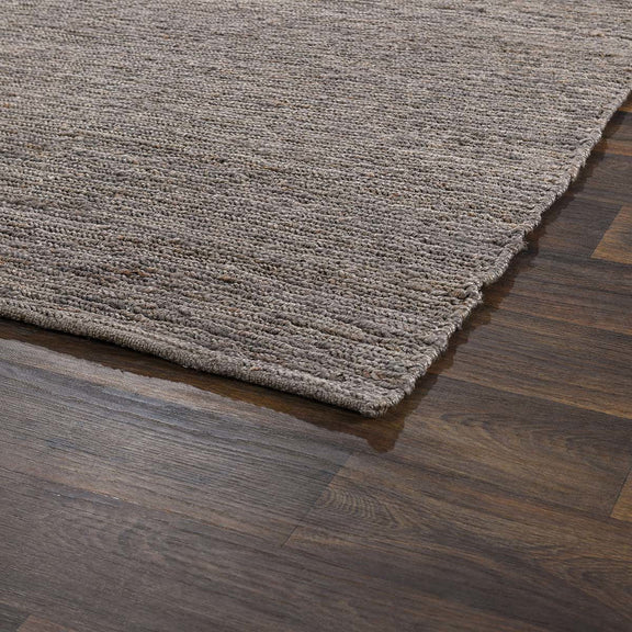 Close-up of gray jute area rug flat weave texture with short fringe along one edge