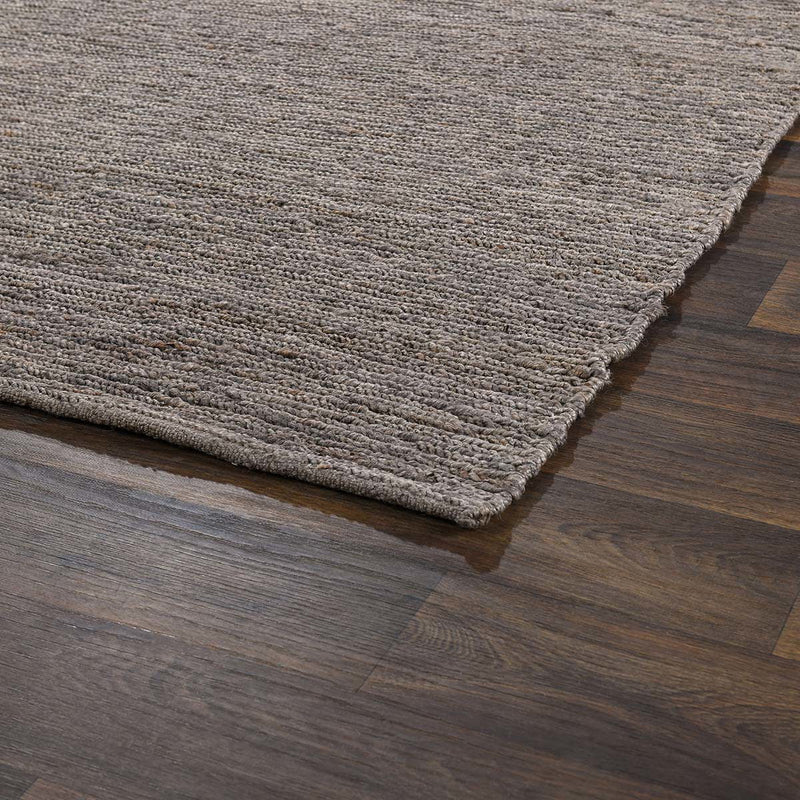 Close-up of gray jute area rug flat weave texture with short fringe along one edge