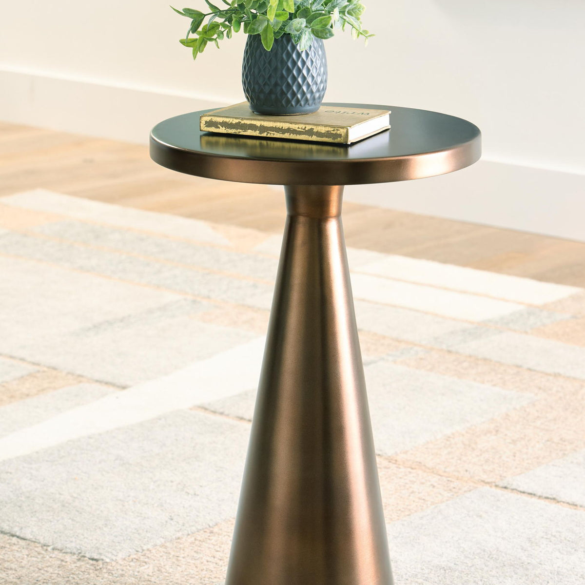 Light bronze accent table with round top and wide flared pedestal base