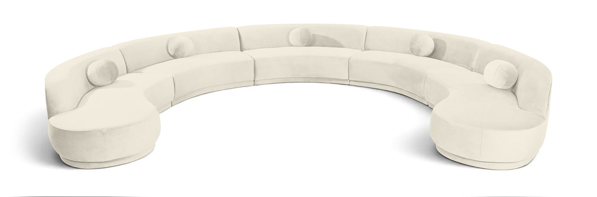 White velvet sectional sofa with rounded, button-tufted seat cushions.