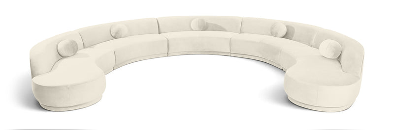 White velvet sectional sofa with rounded, button-tufted seat cushions.