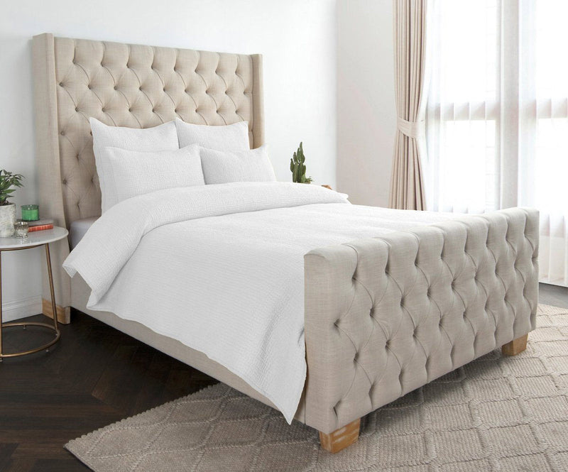 Quilt set with white quilt and matching shams, neatly layered on the bed
