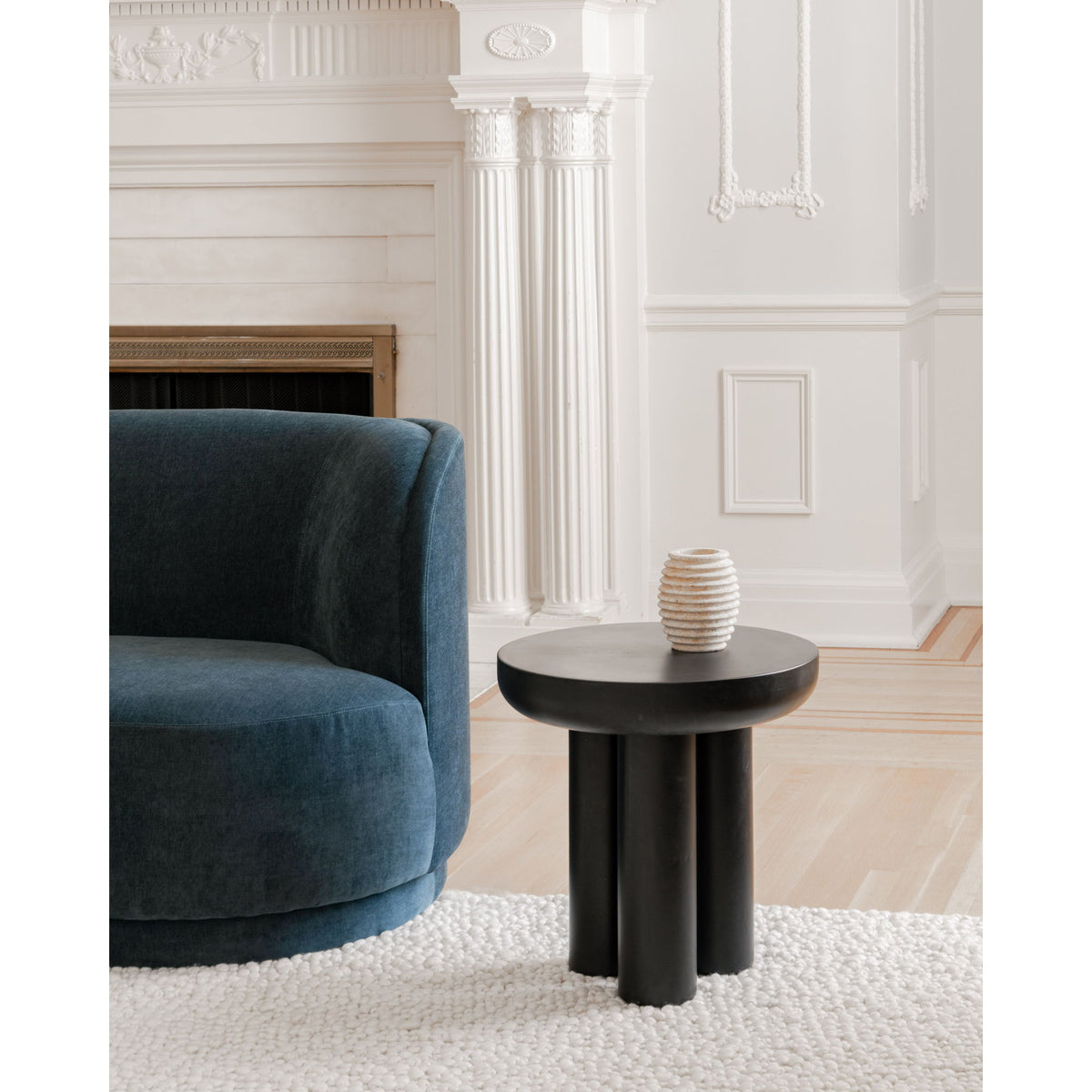 Black round cement side table with thick cylindrical pedestal legs