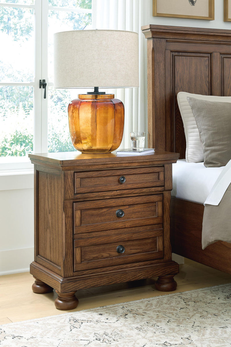 Warm brown wooden nightstand with two drawers, round metal knobs, turned legs