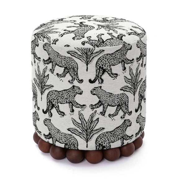Gray cylindrical ottoman with black-and-white animal print and dark wood ball base.