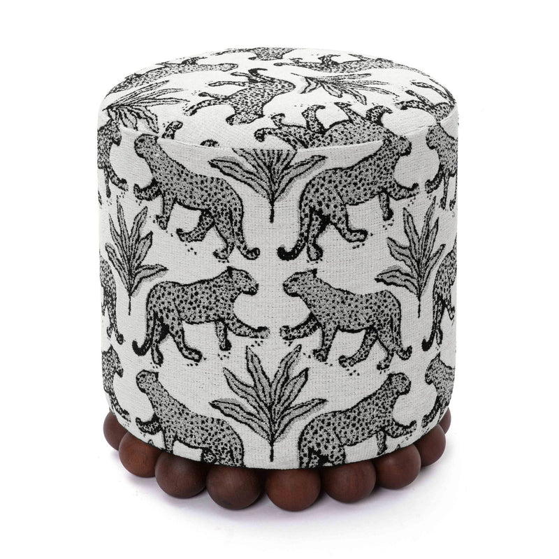 Gray cylindrical ottoman with black-and-white animal print and dark wood ball base.
