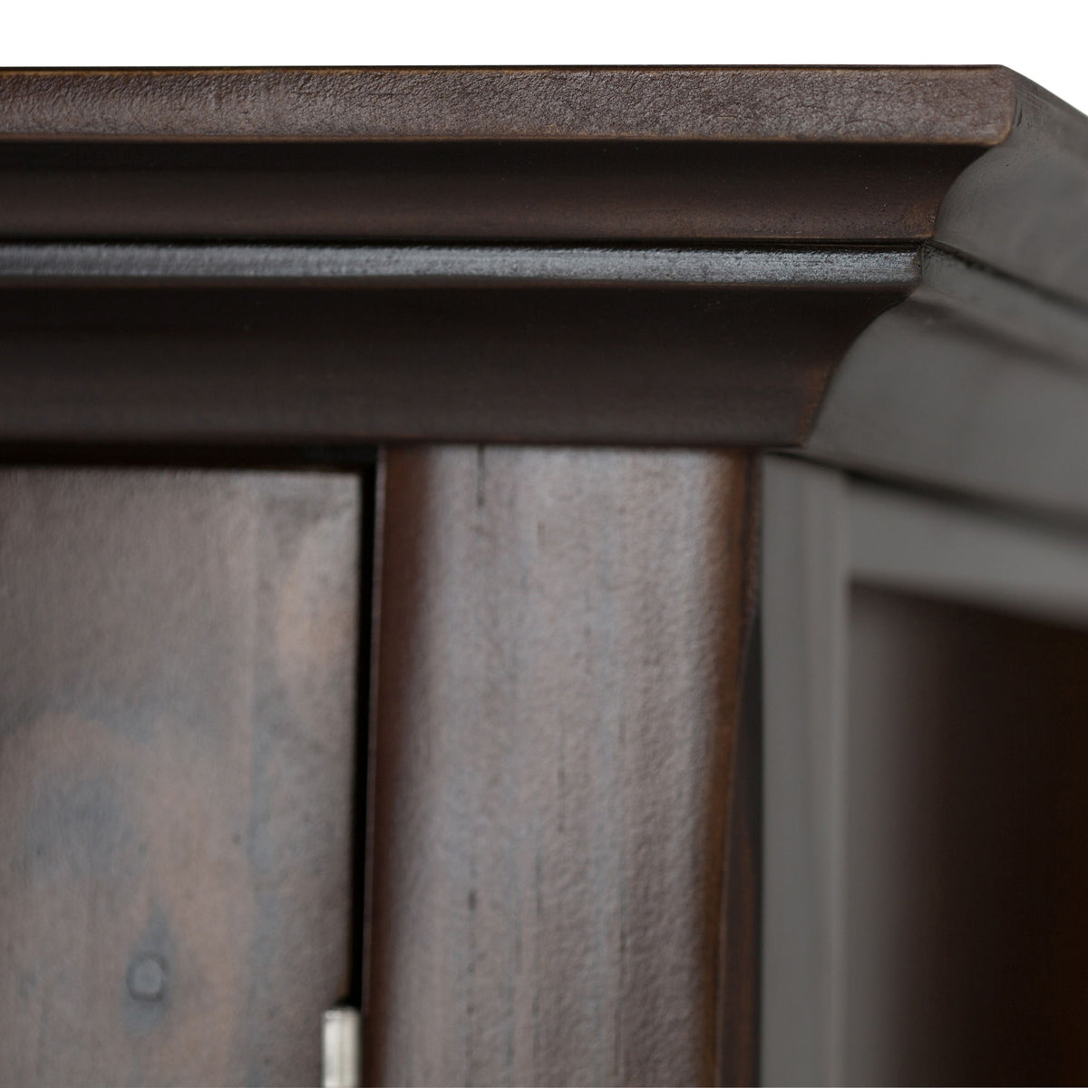 Brunette brown cabinet corner and top trim with visible wood paneling