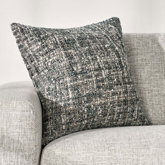 Blue slate woven throw pillow styled on a light fabric sofa cushion.