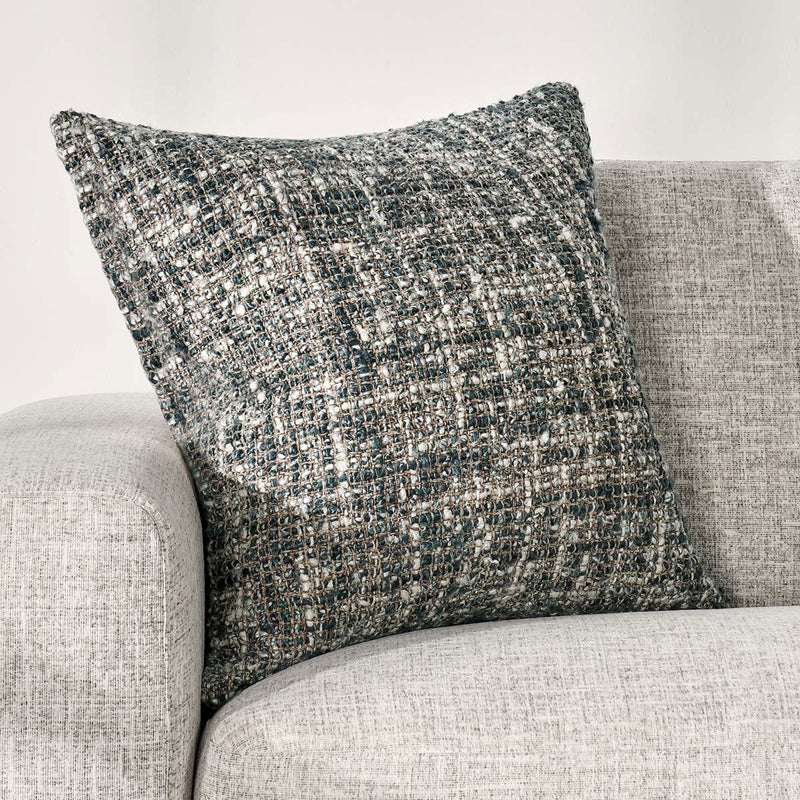 Blue slate woven throw pillow styled on a light fabric sofa cushion.