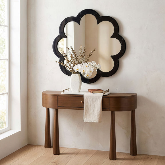 Black cloud-shaped frame mirror on wall above a console vanity with faucet
