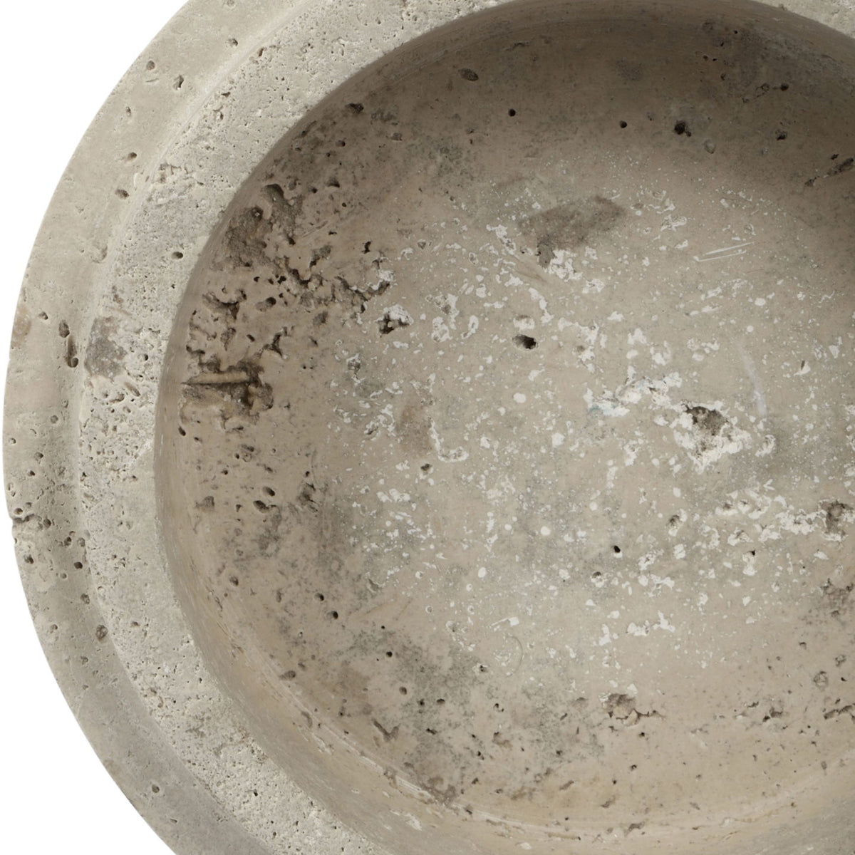 Close-up of light travertine bowl exterior with mottled beige speckles