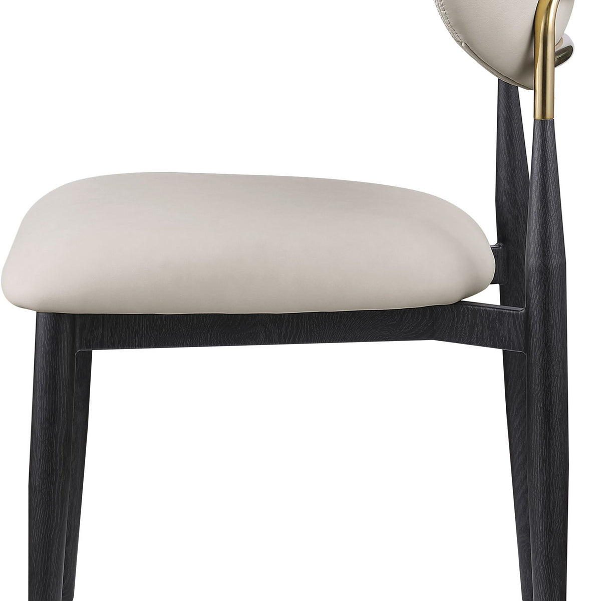 Cream vegan leather dining side chair with padded seat, rounded back, black legs and gold accents