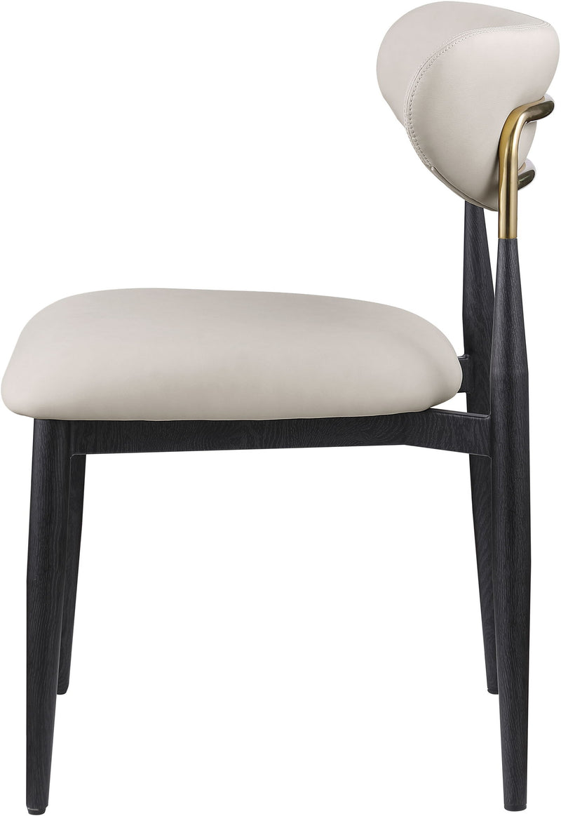 Cream vegan leather dining side chair with padded seat, rounded back, black legs and gold accents