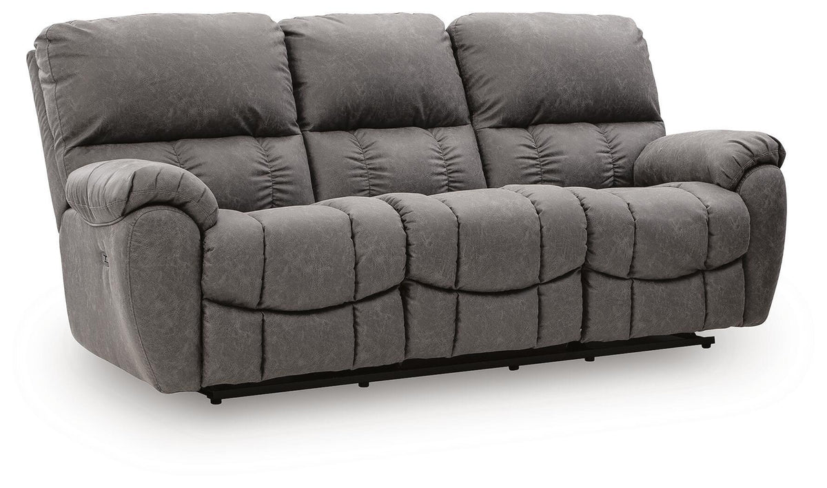 Dark gray reclining sofa with padded arms and adjustable headrests, tufted cushions