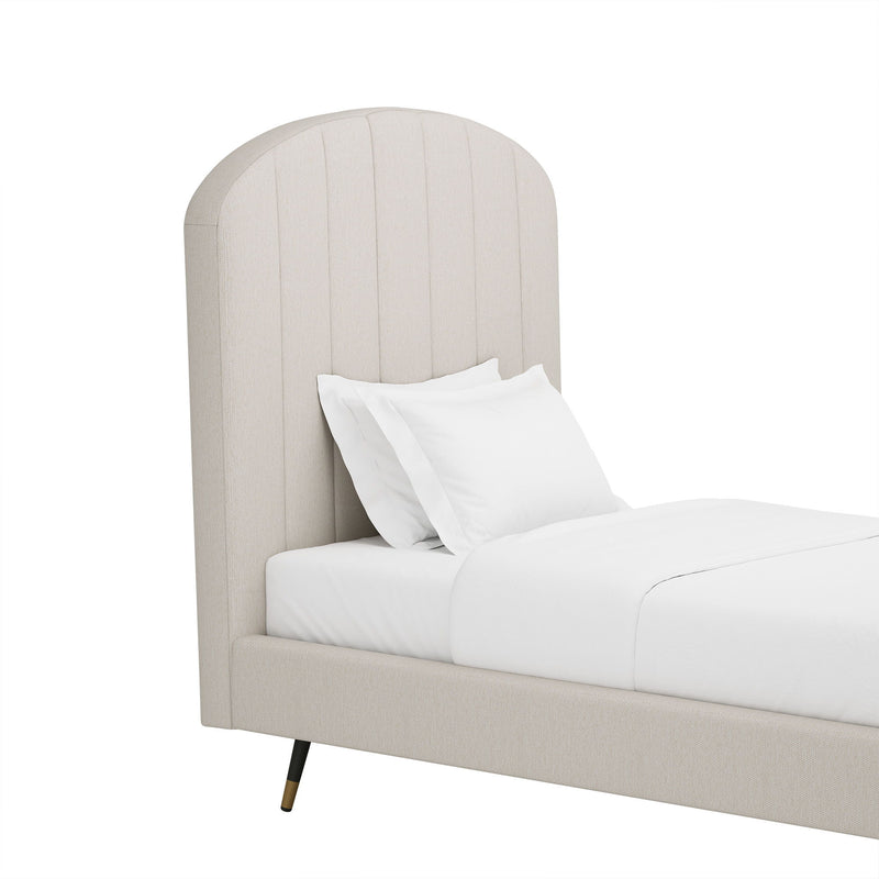 Light beige upholstered bed with arched channel headboard and white pillows