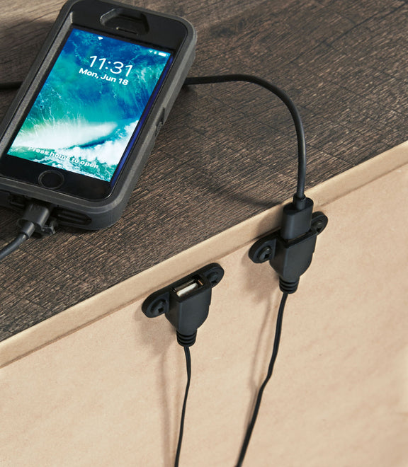Gray night stand top with two drawers; bar pulls visible with phone charging cable