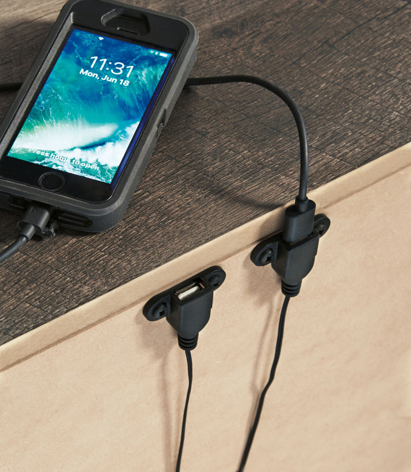 Gray night stand top with two drawers; bar pulls visible with phone charging cable