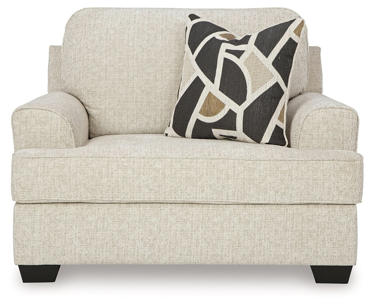 Light gray chair and a half sofa with geometric throw pillow