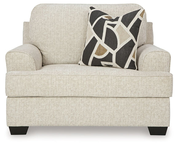Light gray chair and a half sofa with geometric throw pillow
