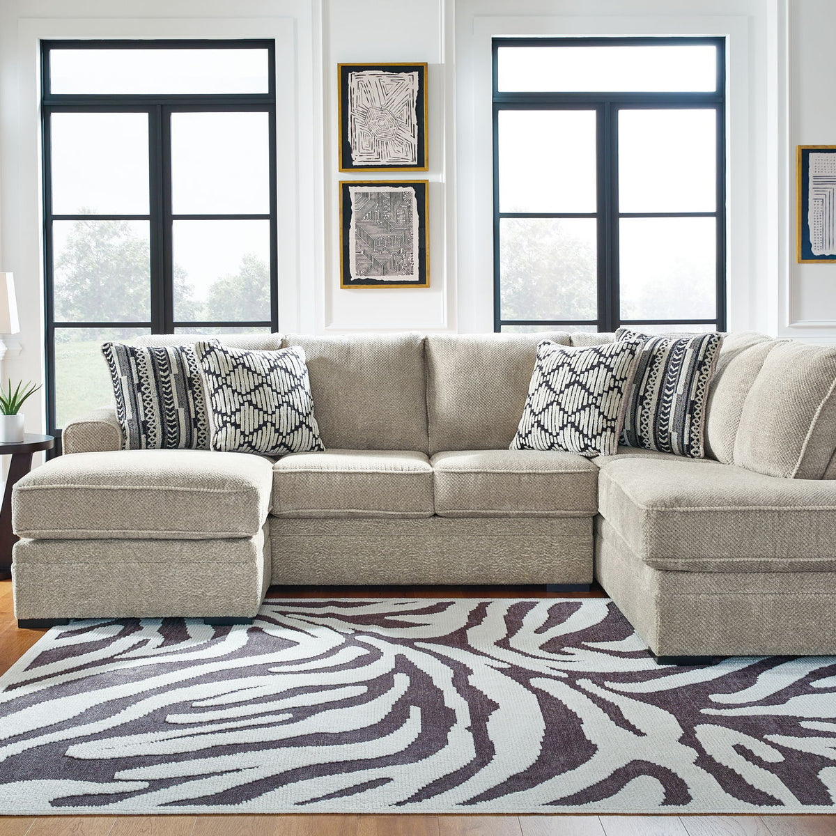 Beige corner chaise sectional sofa with patterned throw pillows and chaise ottomans