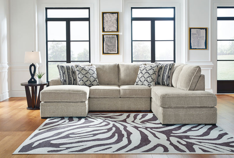 Beige corner chaise sectional sofa with patterned throw pillows and chaise ottomans
