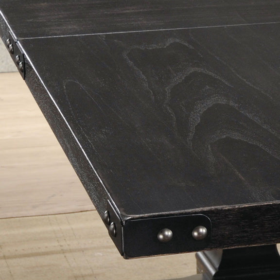 Black dining table edge with metal corner brackets and two round rivets