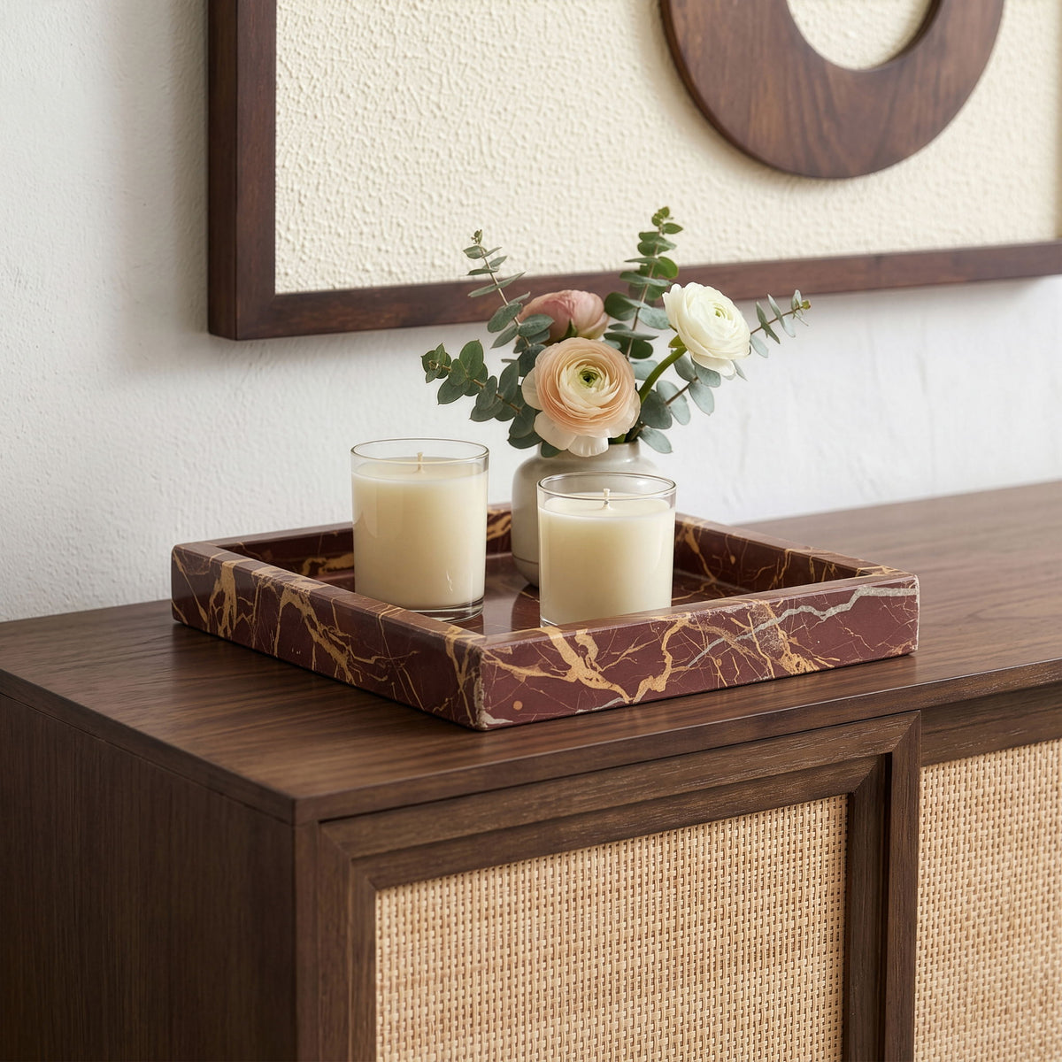Green marble tray with clear glass insert, holding two candles and flowers.