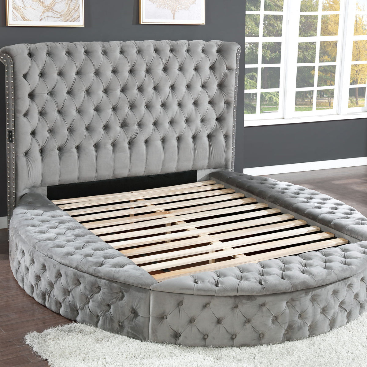 Gray round king bed with tufted headboard and slatted mattress support