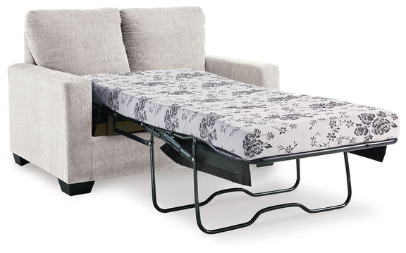 Light beige sofa with pull-out bed frame and floral patterned mattress cover