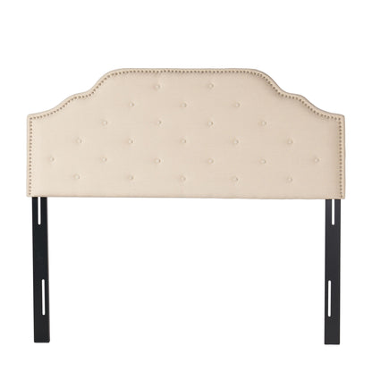 Beige button-tufted upholstered headboard with nailhead trim and dark legs