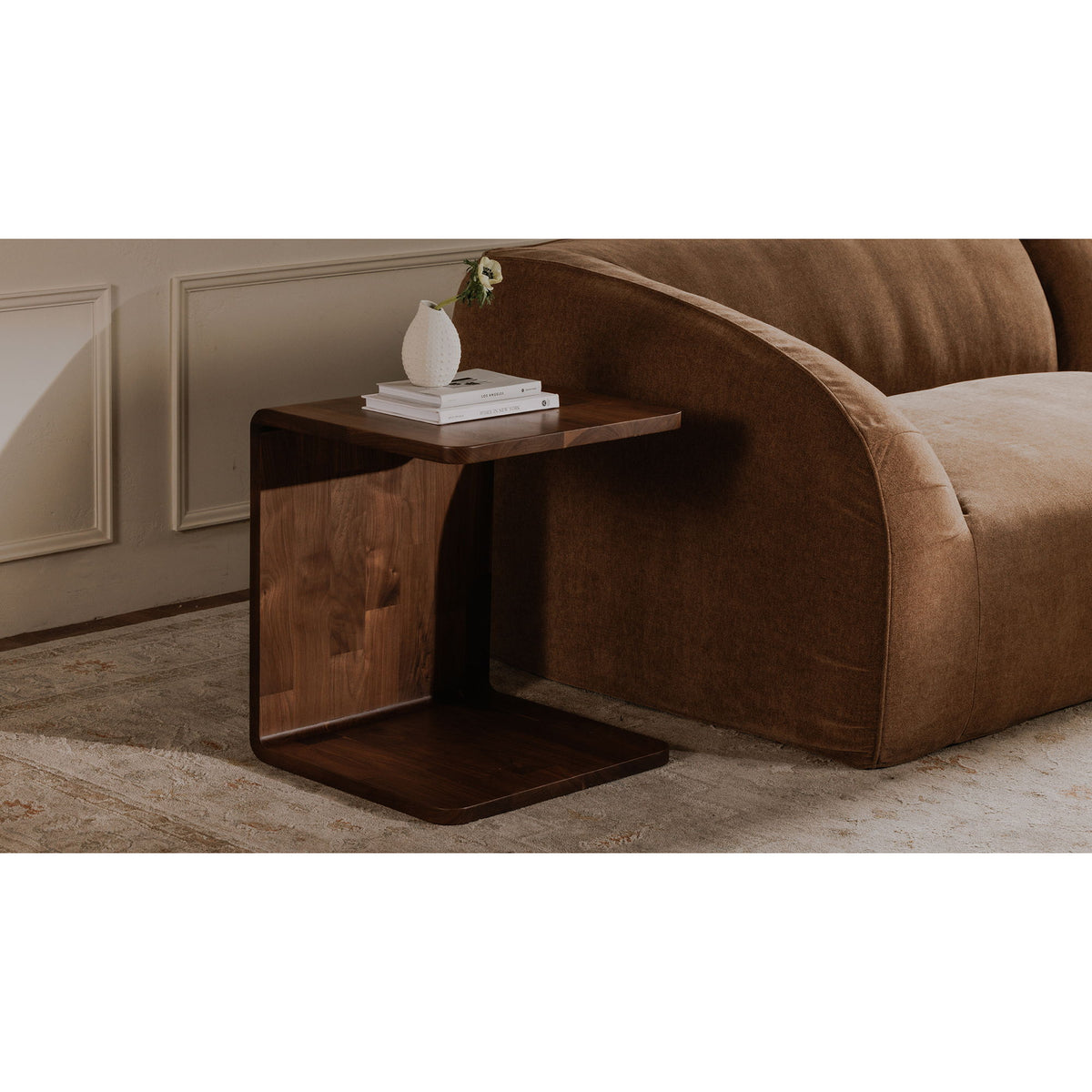 Dark brown wood side table tucked beside a sofa, with an open lower shelf