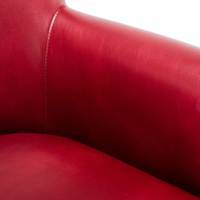 Red leather-look upholstery close-up with stitched seam on club chair arm