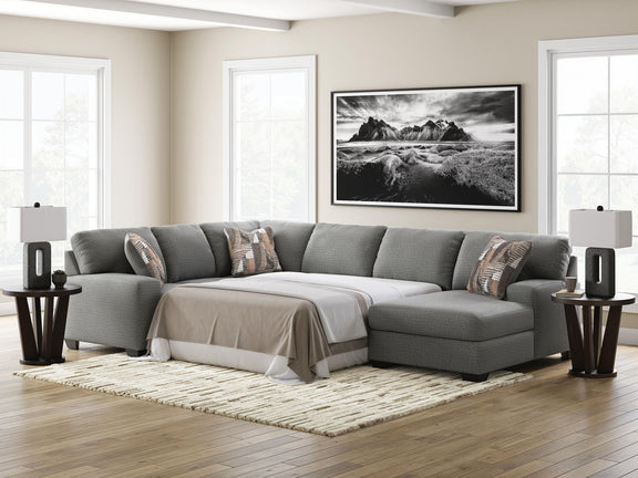 Gray chaise sectional sofa with sleeper cushion and patterned throw pillows