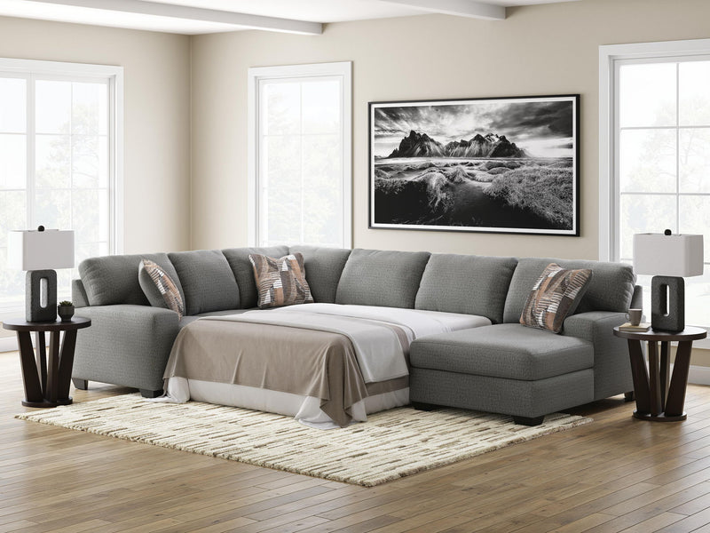 Gray chaise sectional sofa with sleeper cushion and patterned throw pillows