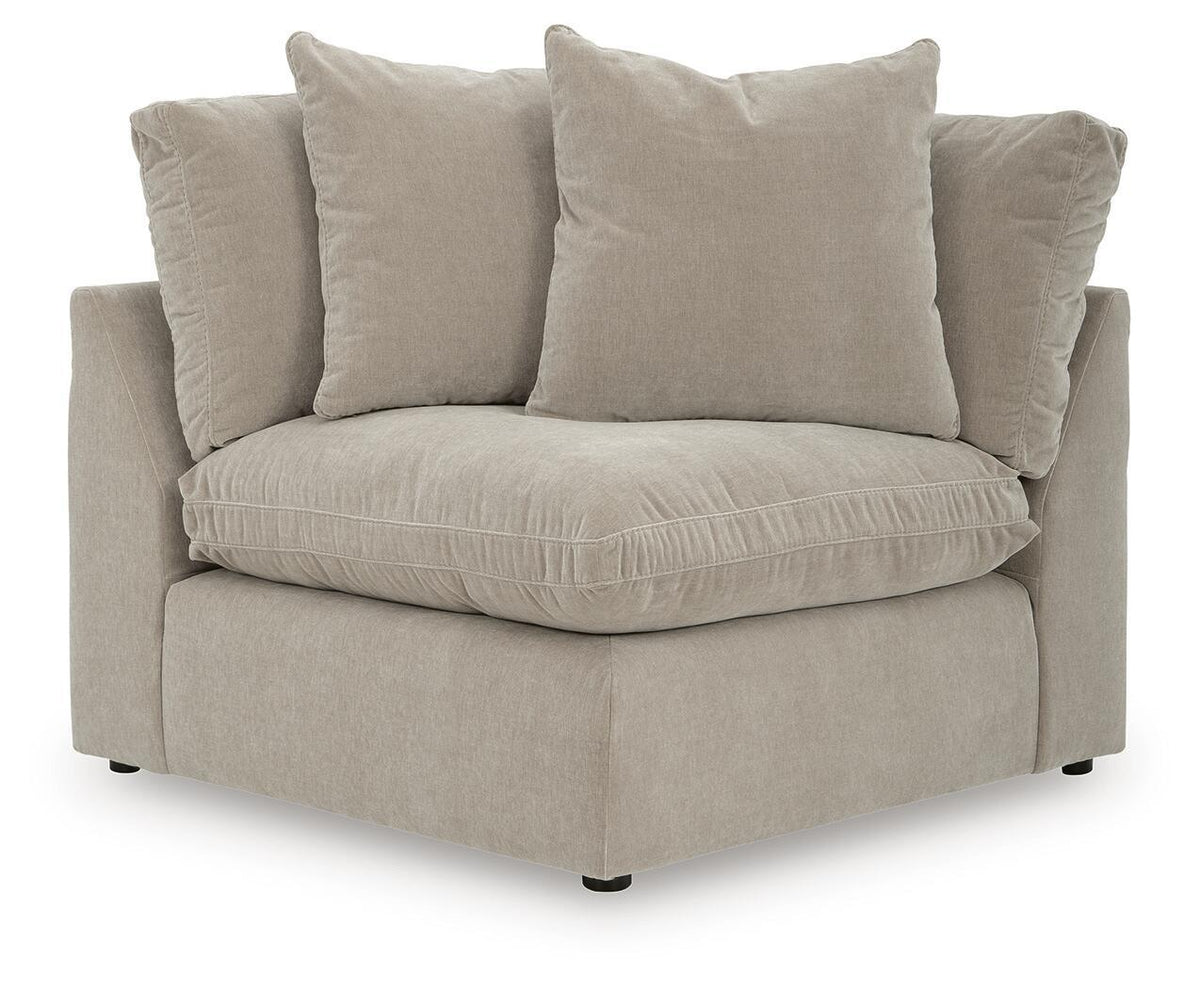 Light beige sectional chaise with three throw pillows and thick seat cushion.