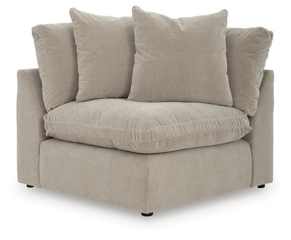 Light beige sectional chaise with three throw pillows and thick seat cushion.