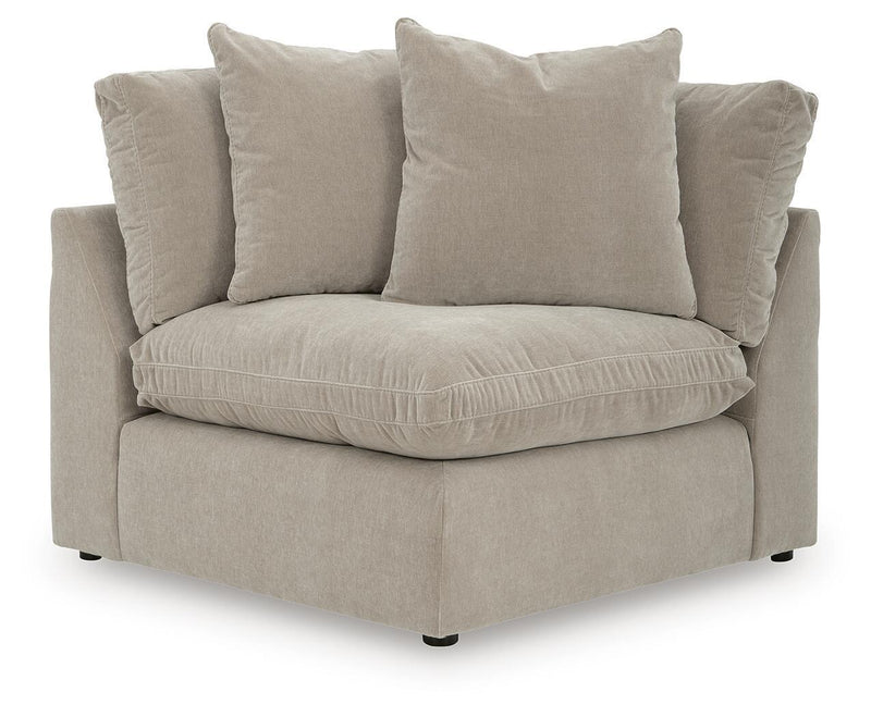 Light beige sectional chaise with three throw pillows and thick seat cushion.
