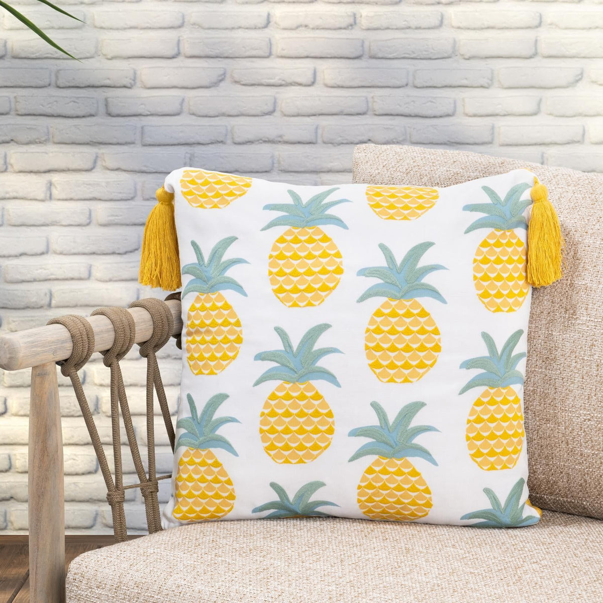 Pineapple print throw pillow with yellow fruit, teal leaves, and mustard tassel trim