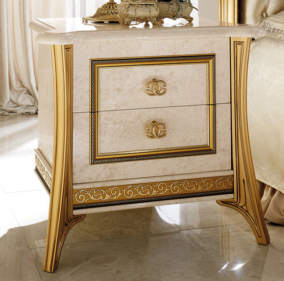 Beige nightstand with gold trim, framed drawer front, ornate patterned apron