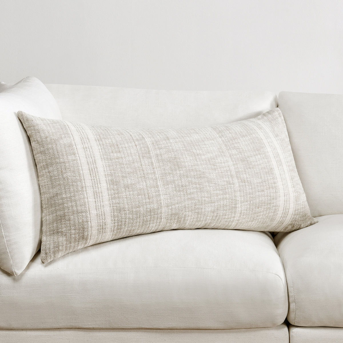 Ivory woven lumbar pillow with central vertical stripe panel on a sofa