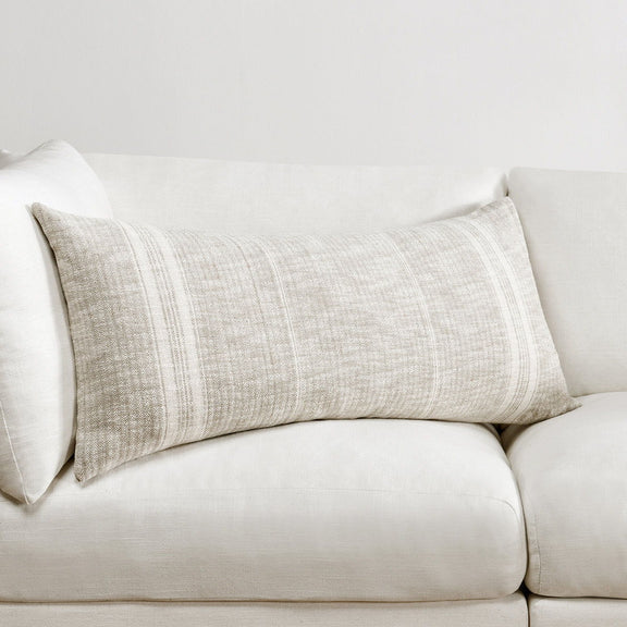 Ivory woven lumbar pillow with central vertical stripe panel on a sofa