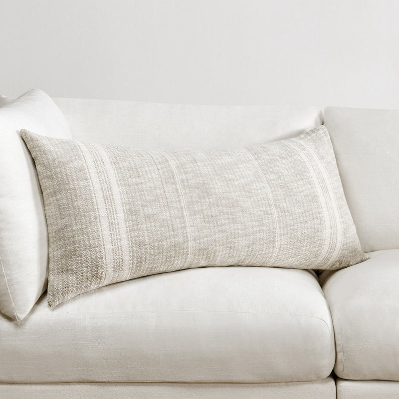 Ivory woven lumbar pillow with central vertical stripe panel on a sofa