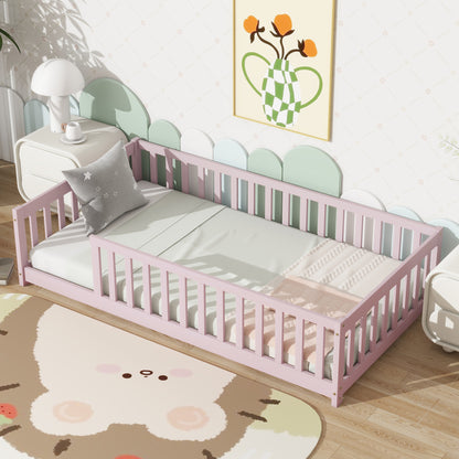 Pink twin floor bed with safety guardrails and fenced headboard, white mattress and gray pillow