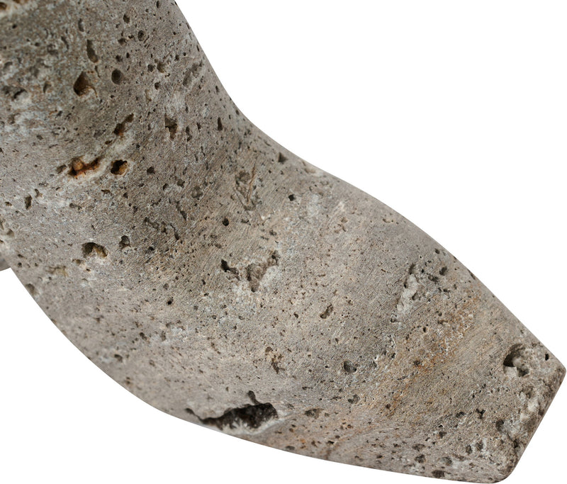 Gray travertine-style high-heel shoe sculpture close-up, speckled stone texture