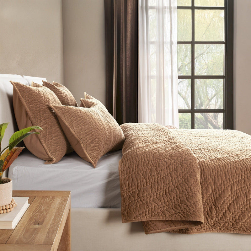 Tan velvet bedding set with matching pillows and draped throw blanket