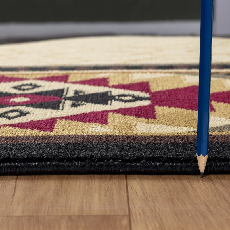 Close-up of beige southwest rug edge with dark binding and maroon geometric pattern